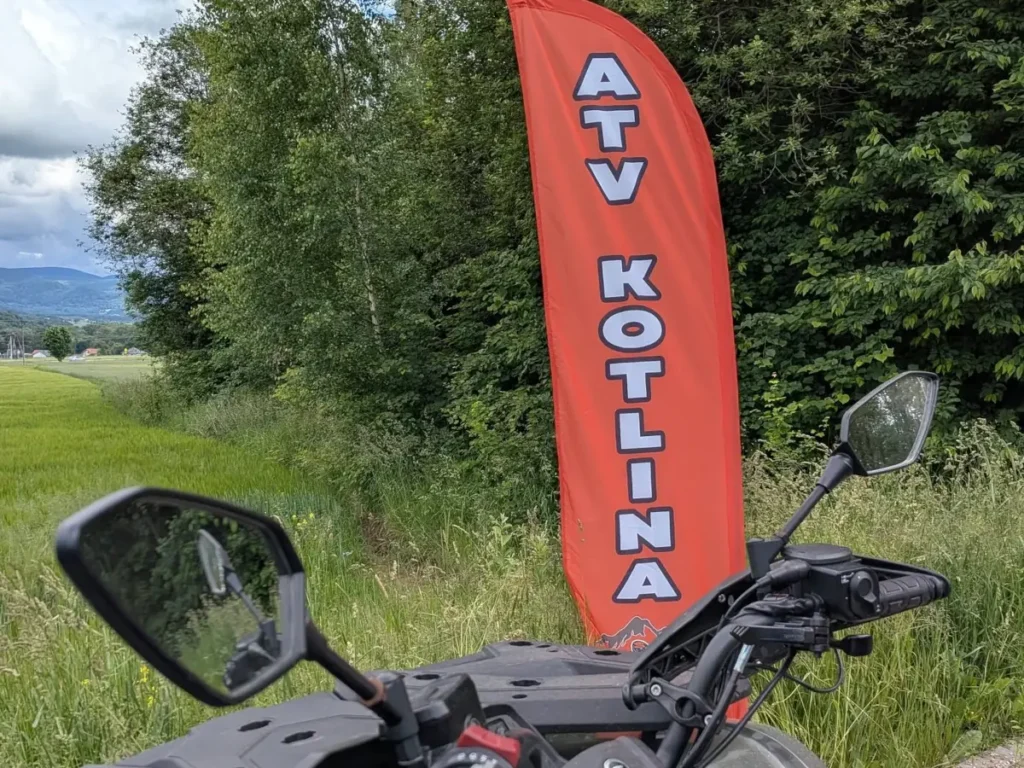 Flaga ze stoiska ATV Kotlina Kłodzka na Motorajdowej Cegiełce 2026 - widok z quada